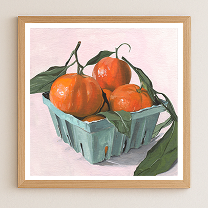 Framed artwork of clementines in a blue carton on a light pink background