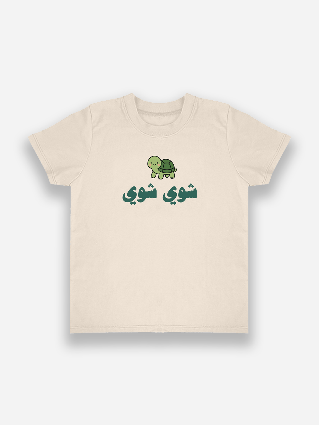 Beige t-shirt with a green turtle graphic and Arabic text on a white background