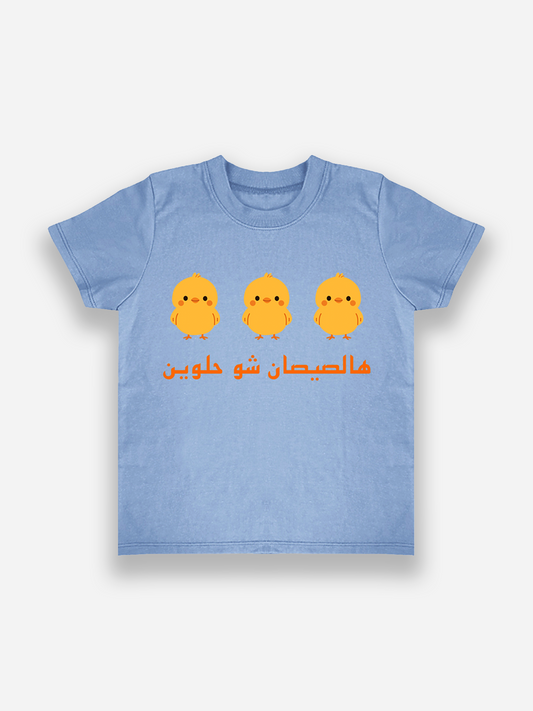 Blue t-shirt with yellow chicks and Arabic text on a white background