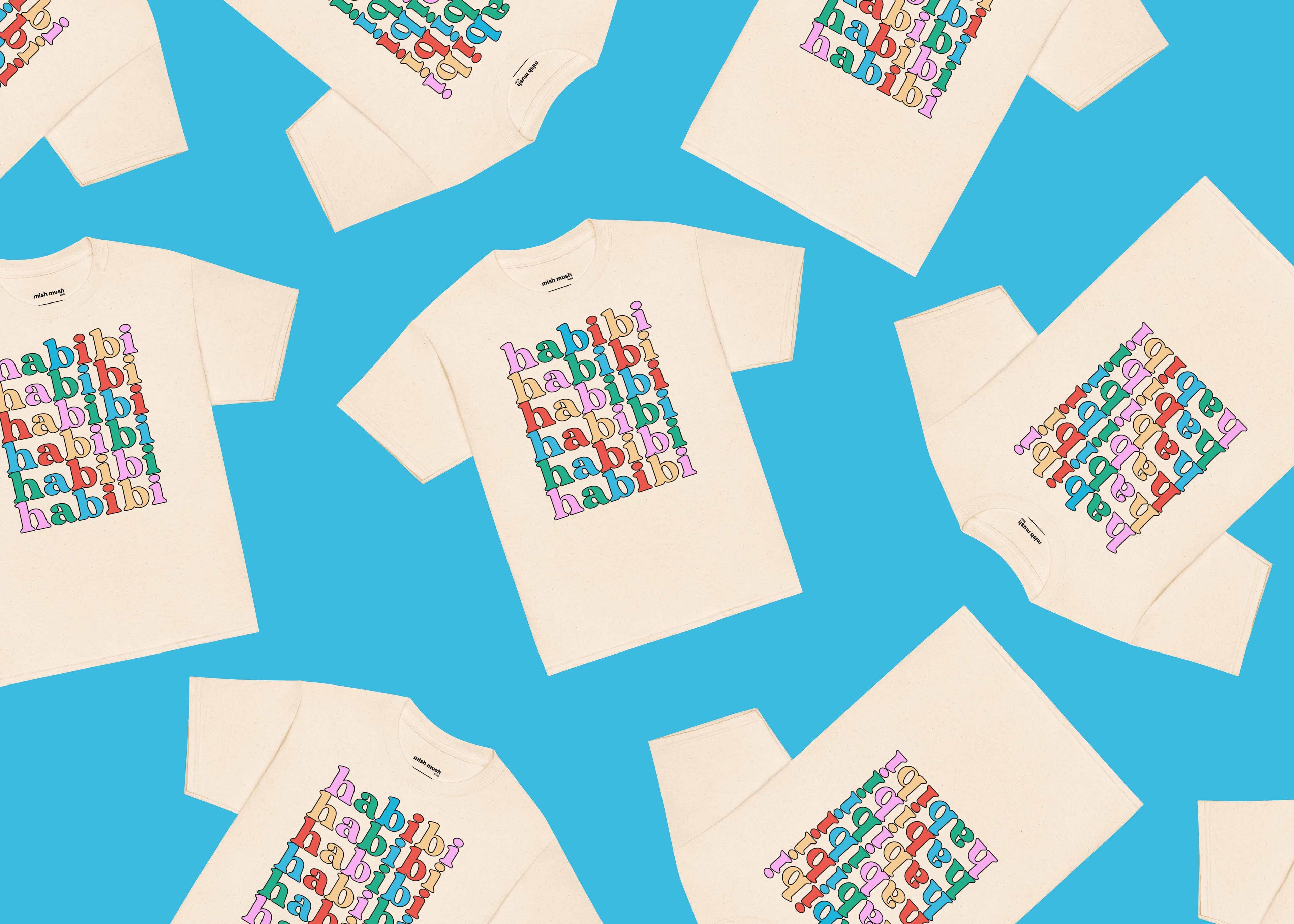 Pattern of white t-shirts with colorful 'habibi' text on a blue background.