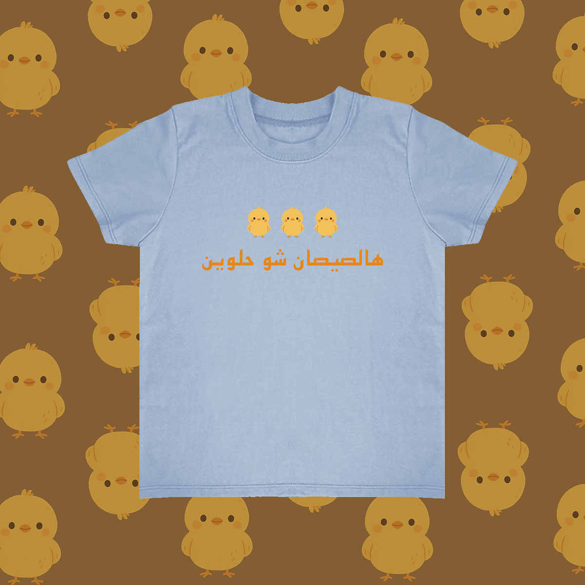 Light blue t-shirt with yellow text on a brown background with yellow chick illustrations
